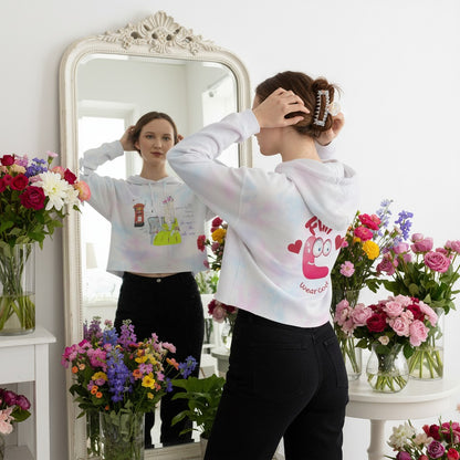 Person wearing a white hoodie with a colorful vintage dressed English lady graphic in a room with flowers and a mirror.