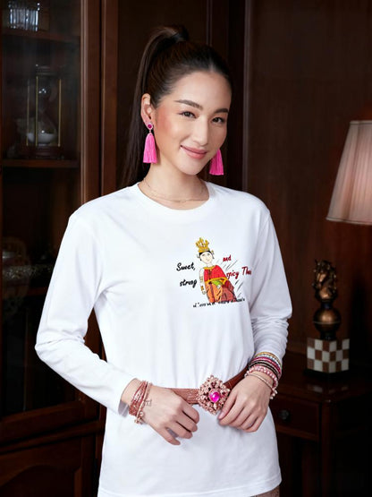 Woman wearing a white long-sleeve shirt with a playful Thai lady graphic and text "fun wear code", standing in an indoor setting.