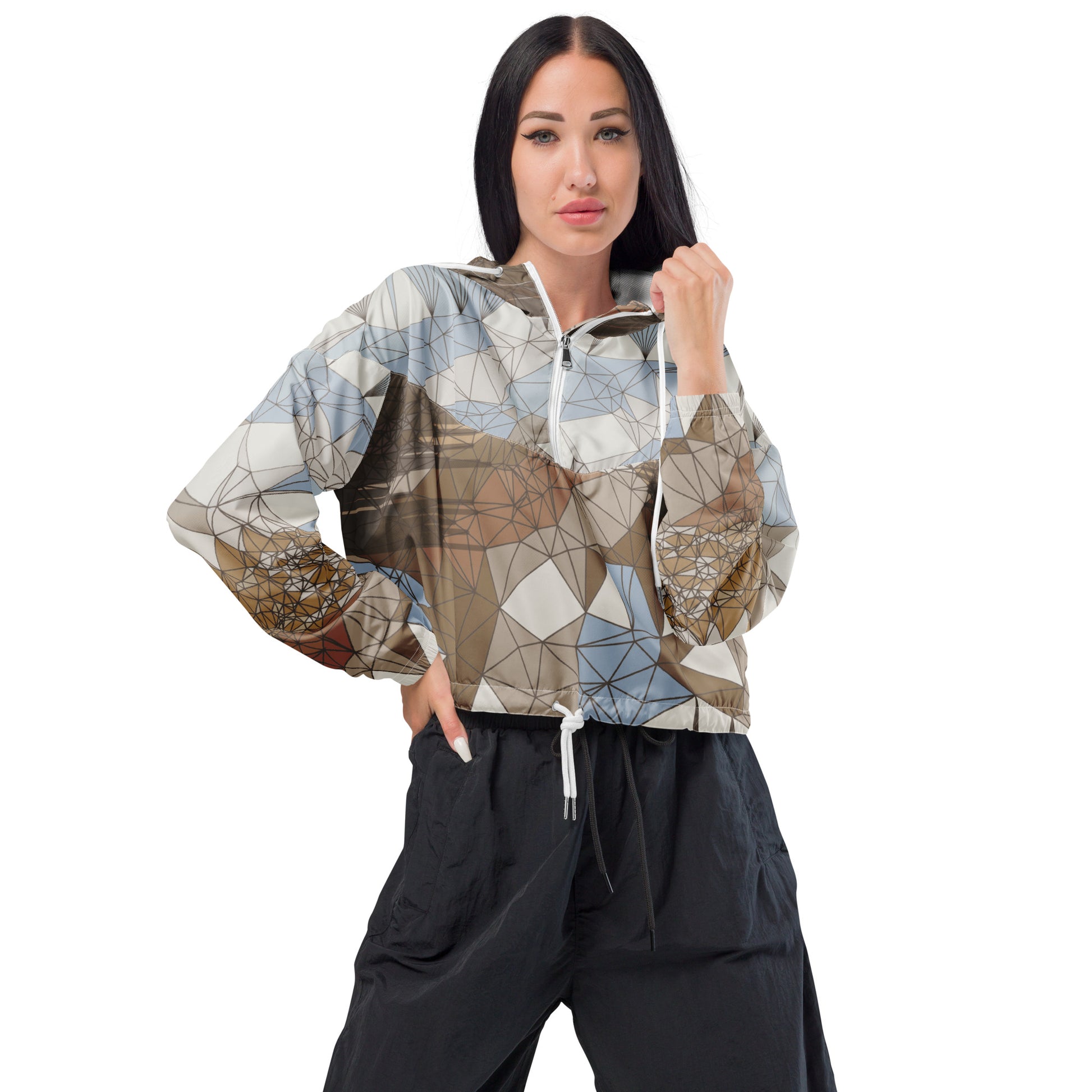 Woman wearing a patterned cropped windbreaker and black pants on a white background