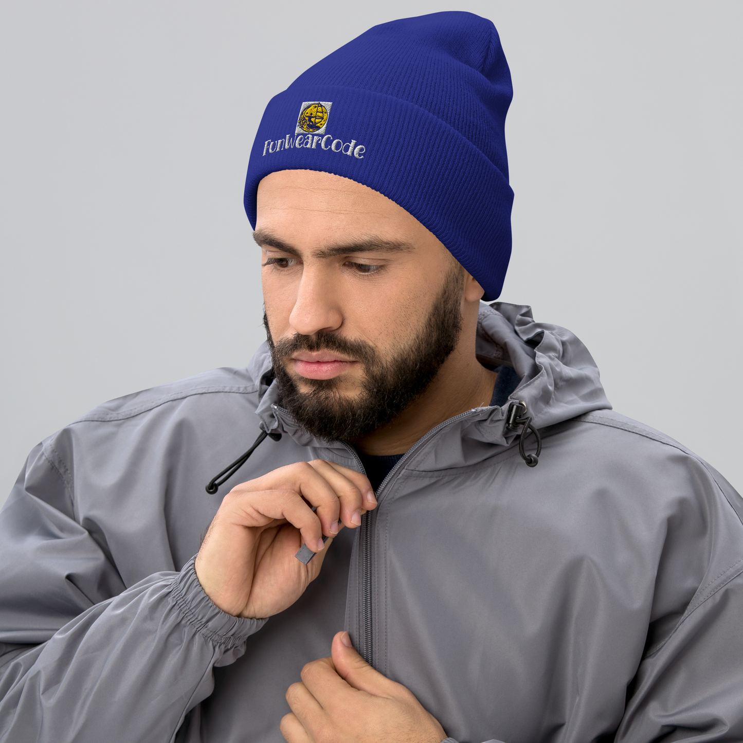 Man wearing a blue beanie with a FunWearCode logo and text, and a gray jacket on a light gray background