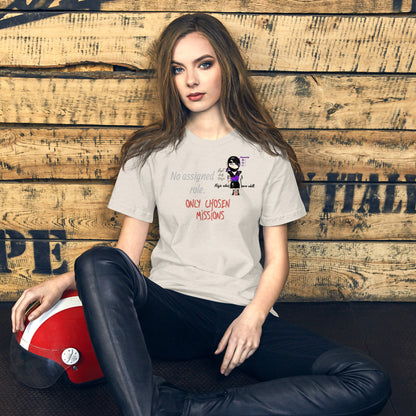 Woman wearing a t-shirt with text and a playful lady ninja graphic design, sitting against a wooden wall.
