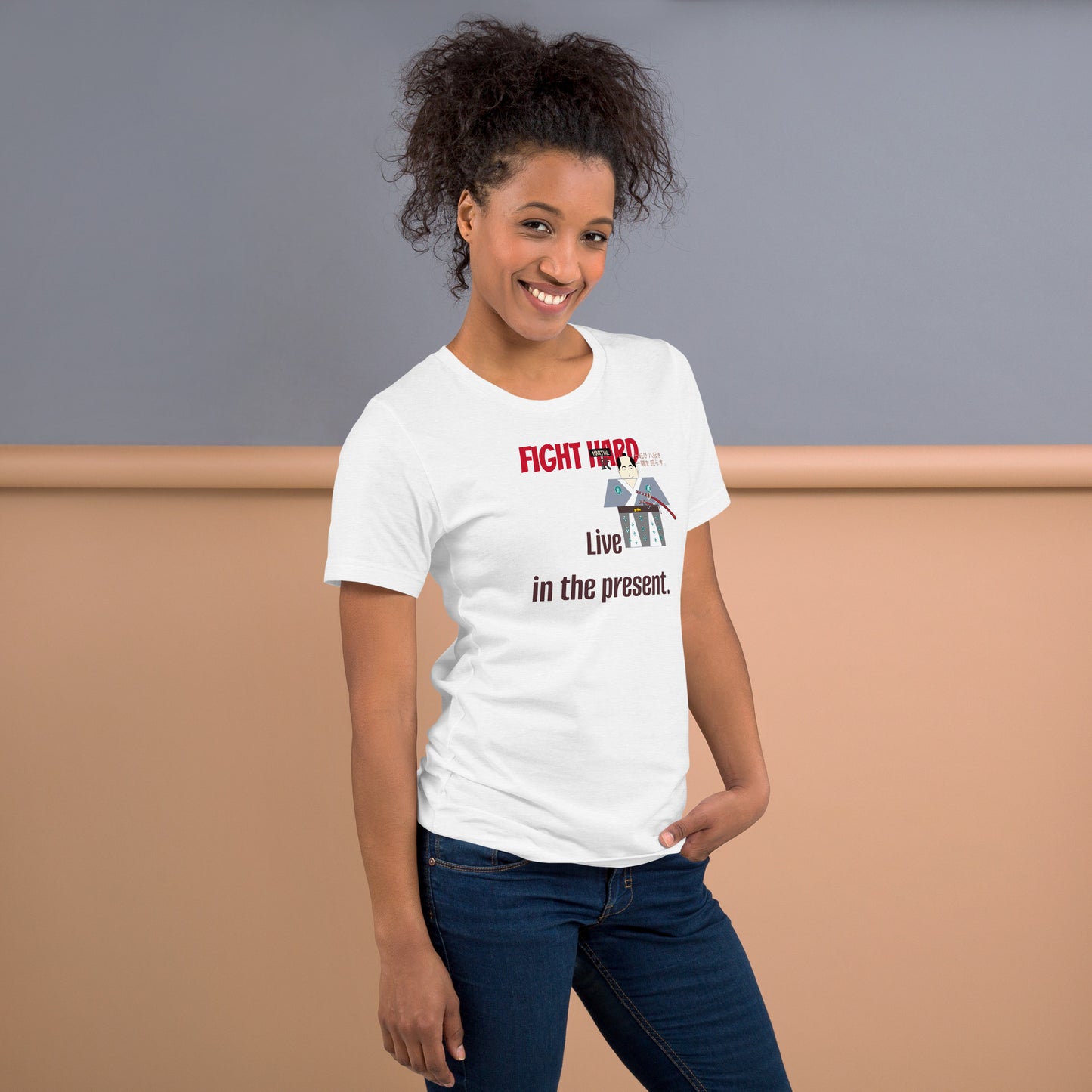 Woman wearing a white t-shirt with a playful samurai graphic and motivational quote, standing against a plain background.