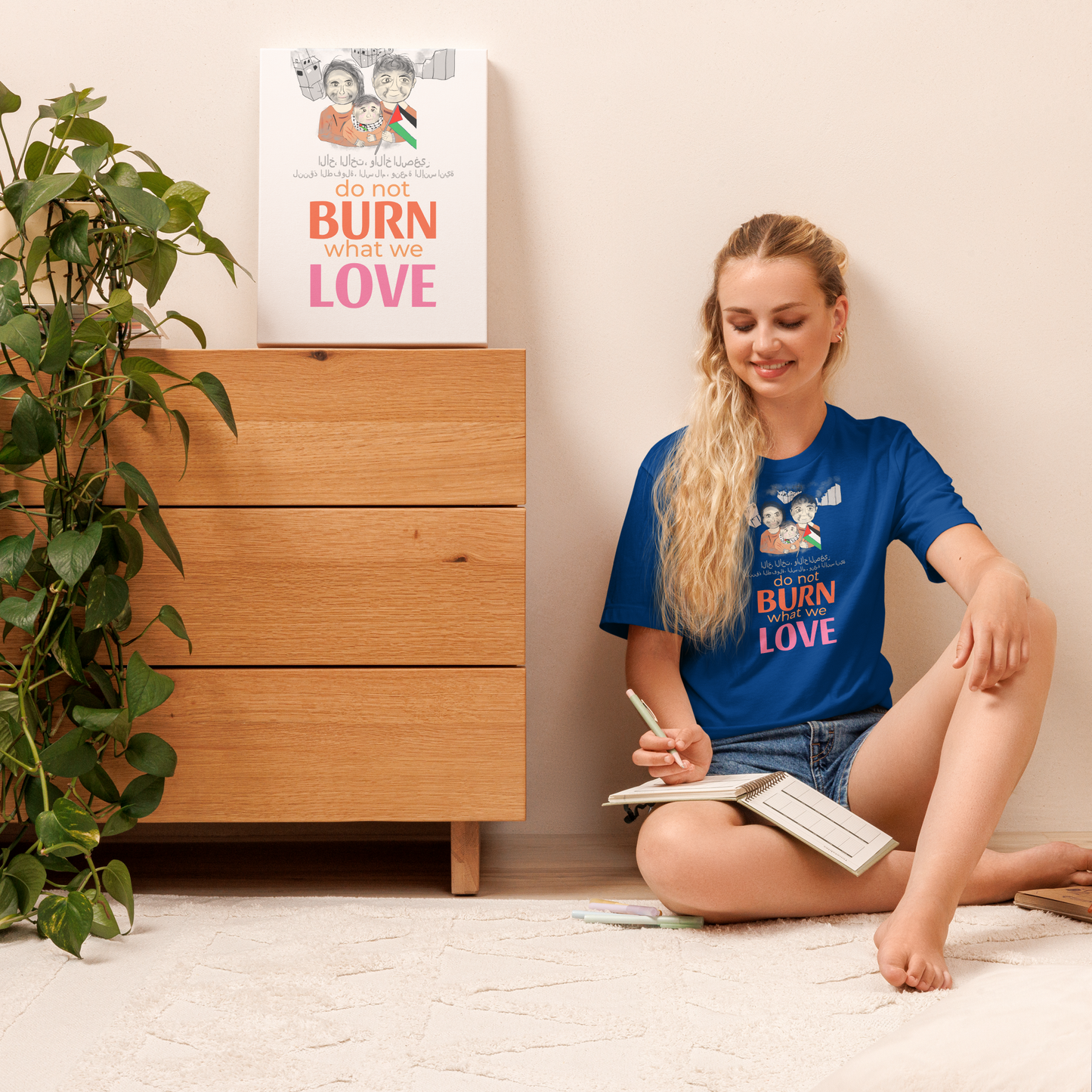 Woman sitting on the floor reading a book with a 'Do not burn what we love' poster in the background.